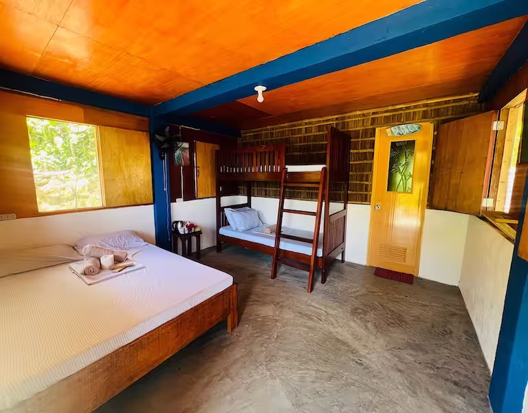 Family room in a La Rivière bungalow with double bed and bunk beds